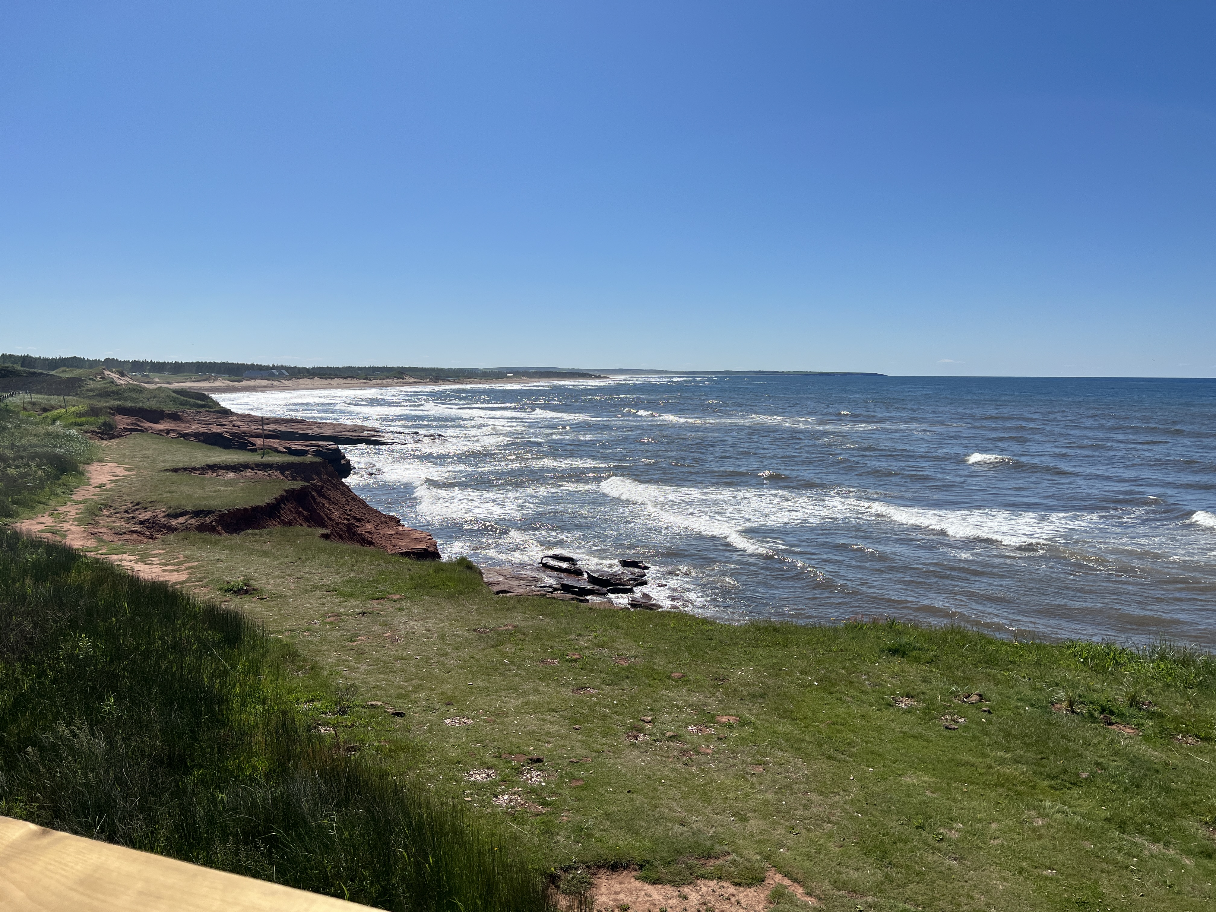 The green grass and red sandstone cliffs embrace the blue sea along Prince Edward Island’s North Shore. Photo by Julie A. Sellers.