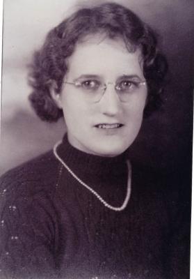 A black-and-white photo of a woman wearing a knitted sweater.