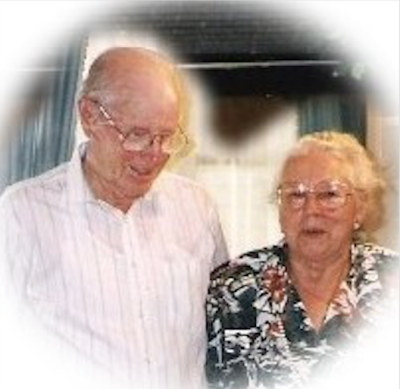 A bald man standing next to a woman in a patterned shirt.