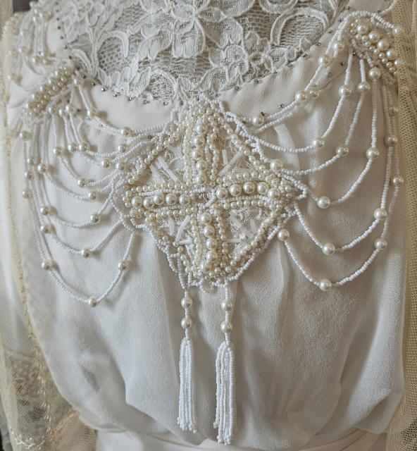 Beading on the cream chiffon and lace bodice of Montgomery’s replica Edwardian wedding gown at her Birthplace in New London, Prince Edward Island.